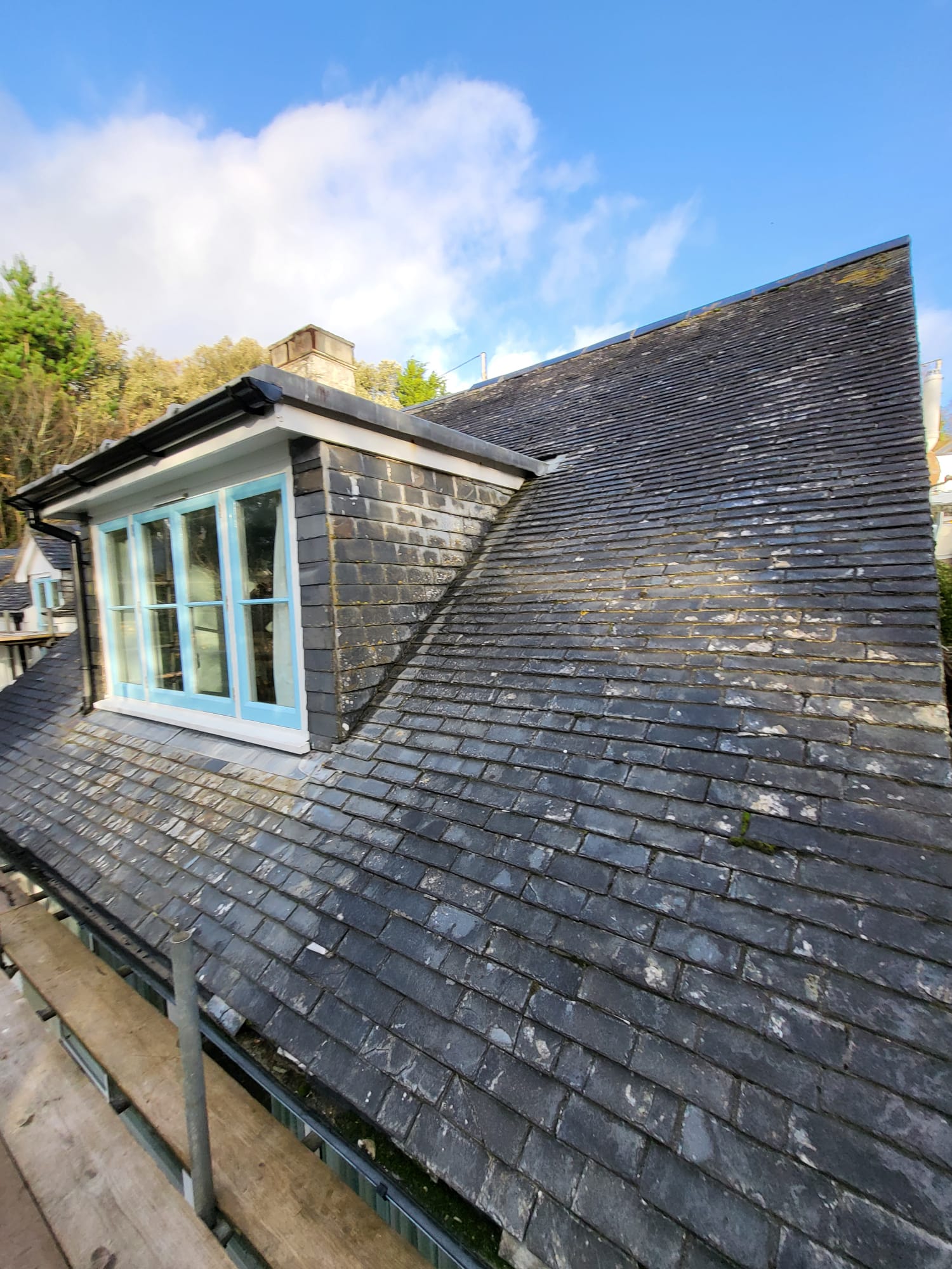 Slate-clad dormer window against a blue Cornish sky